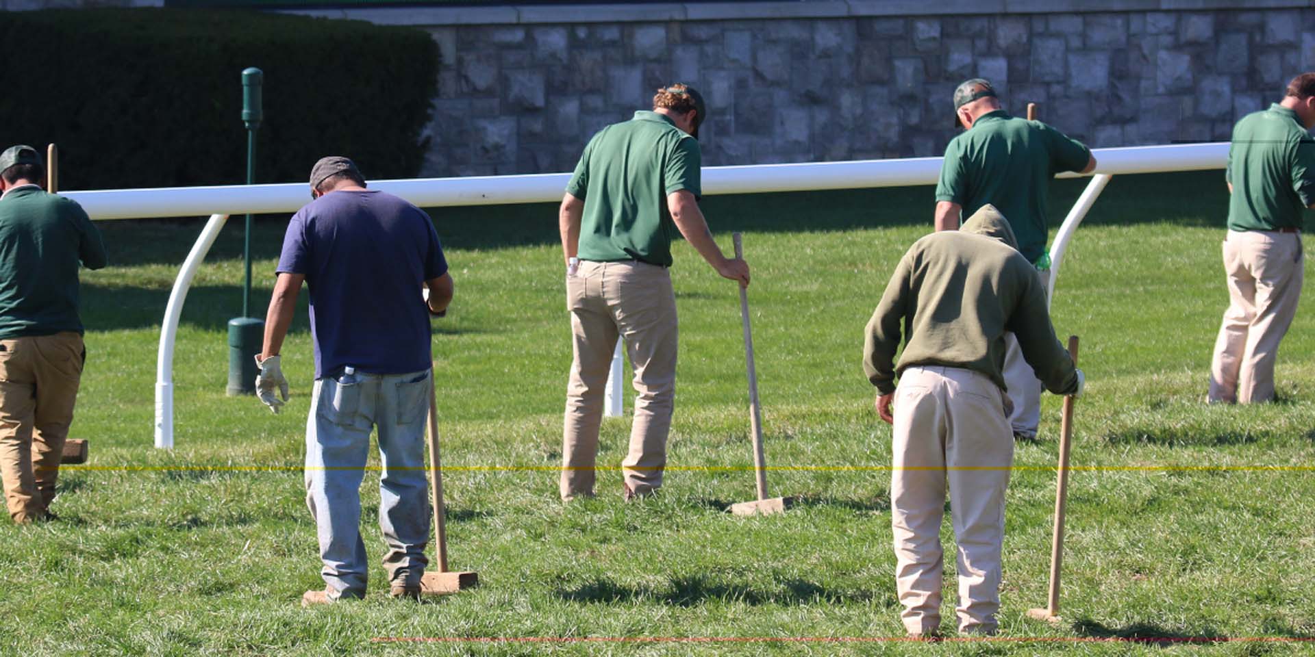 An action shot of Keenraceway team members tamping down turf divots.